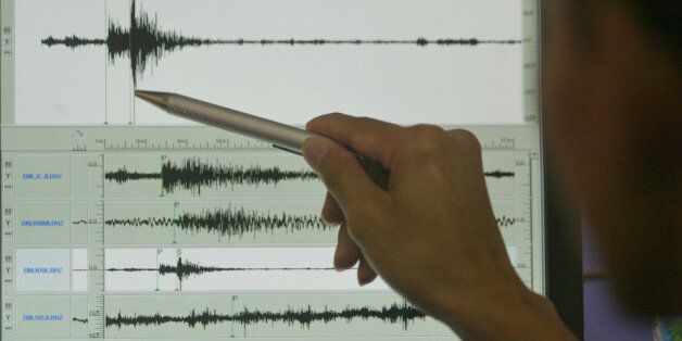 A scientist points to a seismograph reading from this morning's 6.2 magnitude earthquake in Yogyakarta Saturday, May 27, 2006 at the Meteorology and Geophysical Agency in Jakarta, Indonesia. The powerful earthquake rocked Indonesia's Central Java province early Saturday, flattening buildings and killing at least 211 people, hospitals and officials said. Scores of other people were injured. (AP Photo/Irwin Fedriansyah)