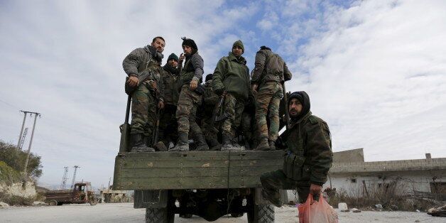 Forces loyal to Syria's President Bashar al-Assad stand on a military truck in the town of Rabiya after they recaptured the rebel-held town in coastal Latakia province, Syria January 27, 2016. Syrian pro-government forces recaptured a key rebel-held town in coastal Latakia province on Sunday, building on battlefield advances in the area ahead of planned peace talks this week in Geneva between Damascus and Syria's opposition. Picture taken during a media tour organised by the government. REUTERS/Omar Sanadiki