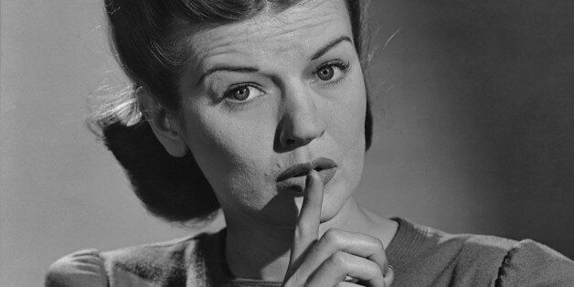 A woman signalling quiet, with her finger up to her lips, in the 1940's. (Photo by Keystone View/FPG/Getty Images)