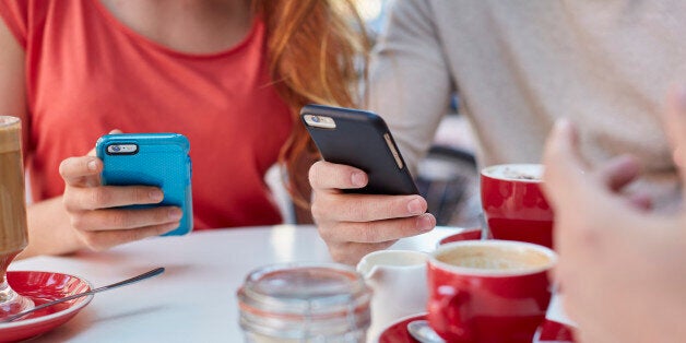 MODEL RELEASED. Young people in cafe using smartphones.