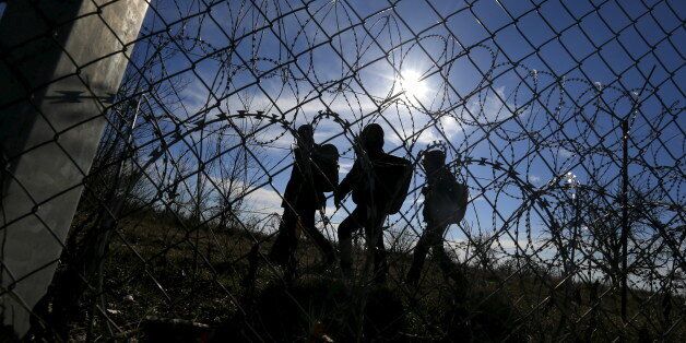 Migrants walk along Hungary's border fence on the Serbian side of the border near Morahalom, Hungary, February 22, 2016. REUTERS/Laszlo Balogh TPX IMAGES OF THE DAY