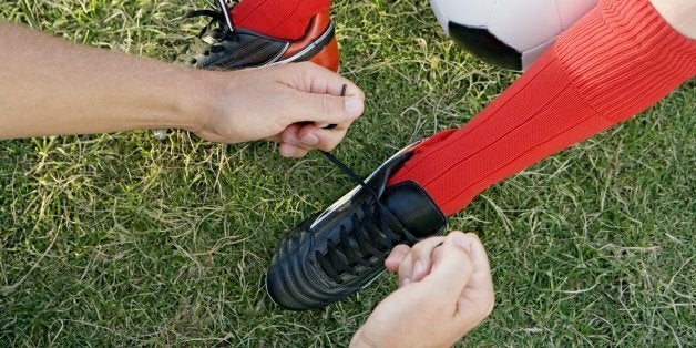 Man helping child tie shoes