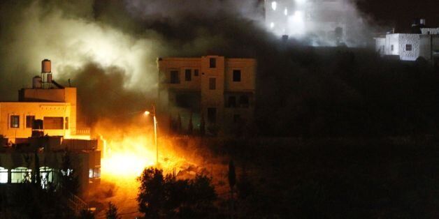 Flames and smoke rise as the Israeli army destroys the house of late Mohammed Nasser Tarayrah, a Palestinian attacker who stabbed to death an Israeli teen in a Jewish settlement, on August 15, 2016 in the village of Bani Naim, near the Palestinian city of Hebron.Mohammed Nasser Tarayrah, 19, broke into a house in the Kiryat Arba Jewish settlement where Hallel Yaffa Ariel was sleeping and stabbed the 13-year-old Israeli-American dozens of times in his bed. Tarayrah was himself killed by settlement guards on June 30, 2016. Israel frequently destroys the homes of Palestinians who have carried out attacks. / AFP / HAZEM BADER (Photo credit should read HAZEM BADER/AFP/Getty Images)