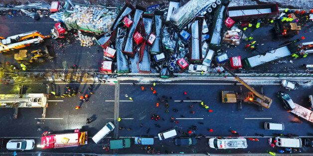 In this Monday, Nov. 21, 2016 photo released by Xinhua News Agency, rescuers work near vehicles collided on the Pingyang section of Beijing-Kunming expressway in north China's Shanxi Province. A vehicle pile-up in snowy weather in northern China that involved more than 50 vehicles has led to the deaths of more than a dozen of people, state media reported Tuesday. (Zhan Yan/Xinhua via AP)
