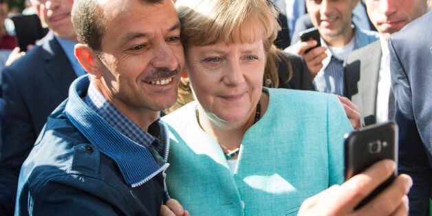 FILE - In this Sept. 9, 2015 file photo German chancellor Angela Merkel poses for a selfie with a refugee in a facility for arriving refugees in Berlin. Media reported Sunday, Nov. Nov. 20, 2016 that Merkel will run for a fourth four-year-term to become one of the longest-serving leaders of post-war Germany. (Bernd von Jutrczenka/dpa via AP)