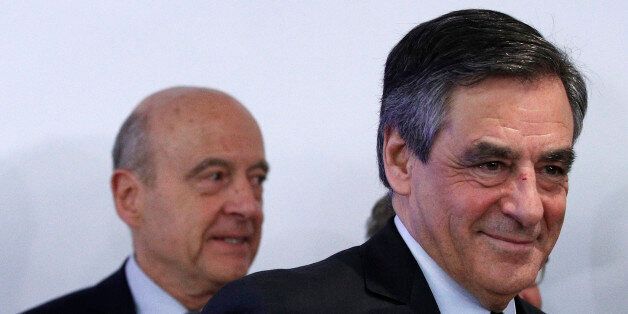 Alain Juppe, left behind, watches Francois Fillon leaving after the conservative presidential primary in Paris, Sunday, Nov. 27, 2016. Fillon won France's first-ever conservative presidential primary after promising drastic free-market reforms and a crackdown on immigration and Islamic extremism, beating a more moderate rival who had warned of encroaching populism. (AP Photo/Christophe Ena)