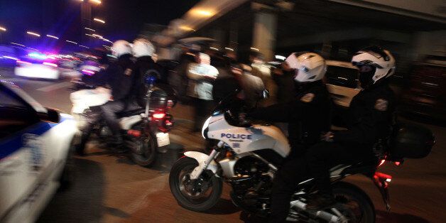Greek police leave the scene of a shooting where three motorcycle policemen were wounded by gunmen in a stolen car, in Rendi suburb of Athens on Tuesday, March 1, 2011. Police say one of the three officers shot in the car chase was in critical condition. (AP Photo/ Petros Giannakouris)