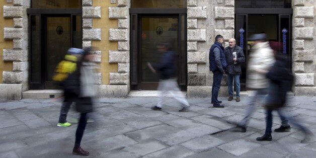 People walk in front of the Monte dei Paschi bank in Siena, central Italy, January 29, 2016. Merger talks between Italian cooperative lenders Banco Popolare and Banca Popolare di Milano (BPM) took a big step forward on Thursday when Rome backed a tie-up. The two banks are at an advanced stage in merger talks and a combination would create Italy's third biggest lender by assets, just ahead of Monte dei Paschi di Siena. If successful, it would likely be the first merger since a reform of large cooperative lenders last year to encourage consolidation and strengthen Italy's fragmented banking system and could pave the way for a parallel deal between UBI, which had courted BPM, and Monte dei Paschi di Siena. REUTERS/Max Rossi