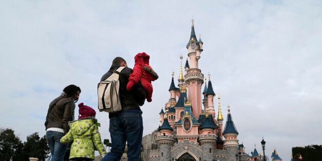 Visitors walk towards the Sleeping Beauty Castle during a visit to the Disneyland Paris Resort run by EuroDisney S.C.A in Marne-la-Vallee January 21, 2015. Picture taken January 21, 2015. To match Special Report EURODISNEY-SHAREHOLDERS/ REUTERS/Gonzalo Fuentes (FRANCE - Tags: BUSINESS SOCIETY TRAVEL)