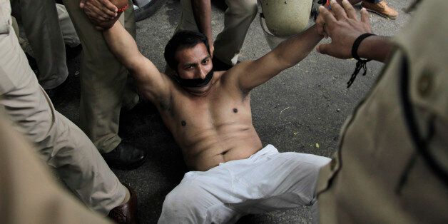 Indian policemen try to stop a bare chest protester of India's opposition Congress party's youth wing during a protest in New Delhi, India, Thursday, Aug. 6, 2015. The protesters demonstrated against the decision of Lok Sabha, or the lower house speaker, Sumitra Mahajan of the ruling Bharatiya Janata Party (BJP), who suspended 25 Congress party members from the Lok Sabha. The opposition also continued to demand the resignation of the two leaders of BJP for allegedly helping a former Indian crick