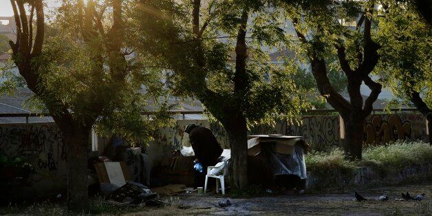 A homeless woman is seen near her belongings in central Athens, early Wednesday, May 13, 2015. Greece, which is in the midst of protracted bailout talks with creditors, is now officially in recession again according to data released Wednesday, less than a year after it emerged from a six-year depression. (AP Photo/Petros Giannakouris)