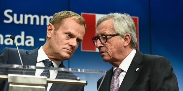 President of the European Commission Jean-Claude Juncker talks to EU Council President Donald Tusk (L) during a joint press conference with Canadian Prime Minister after the signing of the Comprehensive Economic and Trade Agreement (CETA), on October 30, 2016 at the European Union headquarters in Brussels. The EU and Canada finally signed a landmark free trade deal seven years in the making on October 30, 2016, after overcoming last-minute resistance from a small Belgian region that nearly torpedoed the entire agreement. CETA removes 99 percent of customs duties between the two sides, linking the single EU market of 28 nations with the world's 10th largest economy. / AFP / JOHN THYS (Photo credit should read JOHN THYS/AFP/Getty Images)