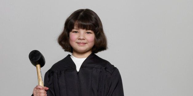 Girl (5-7) wearing judicial robe, holding gavel, portrait