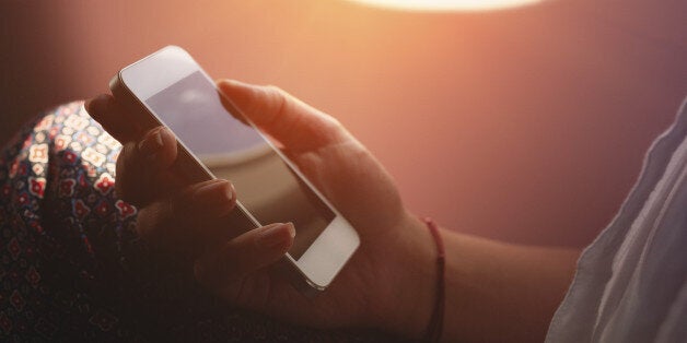 Woman using smartphone in airplane during flight