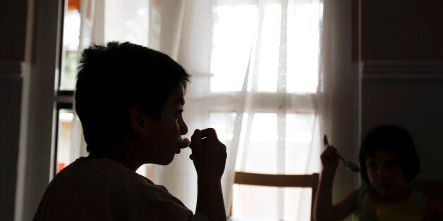 Children have lunch in a community home run by