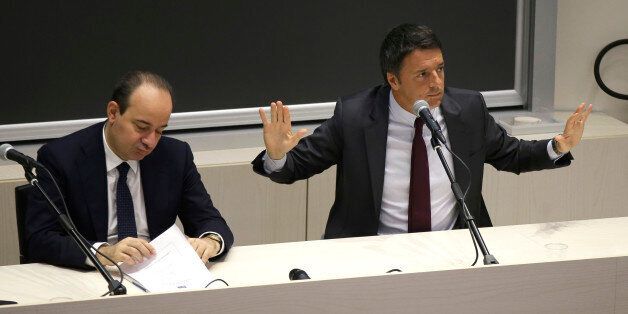 Italian premier Matteo Renzi, right, flanked by rector Franco Anelli, talks during a meeting with students of the Cattolica University in Milan, Italy, Monday, Nov.14. 2016. (AP Photo/Luca Bruno)