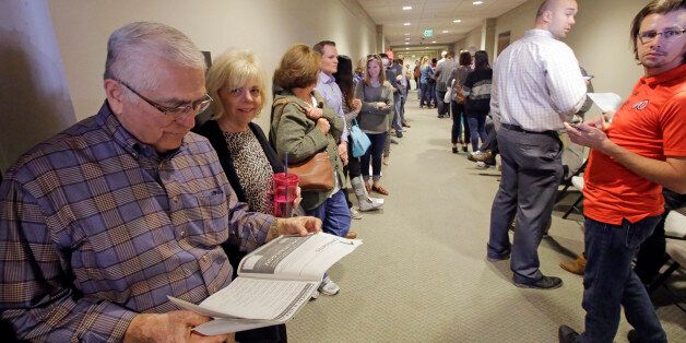 Frank Medina, left, reads the voter information pamphlet as he waits in line to vote at the Holladay City Hall Tuesday, Nov. 8, 2016, in Holladay, Utah. Utah's mostly Mormon, mostly Republican voters are going to the polls Tuesday to determine if the GOP's five-decade winning streak in presidential elections will remain intact or be snapped. (AP Photo/Rick Bowmer)