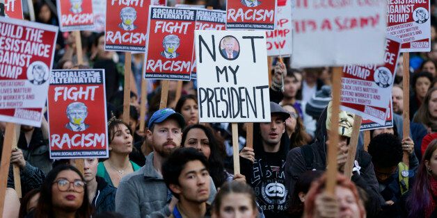 Protesters hold signs during a protest against the election of President-elect Donald Trump, Wednesday, Nov. 9, 2016, in downtown Seattle. (AP Photo/Ted S. Warren)