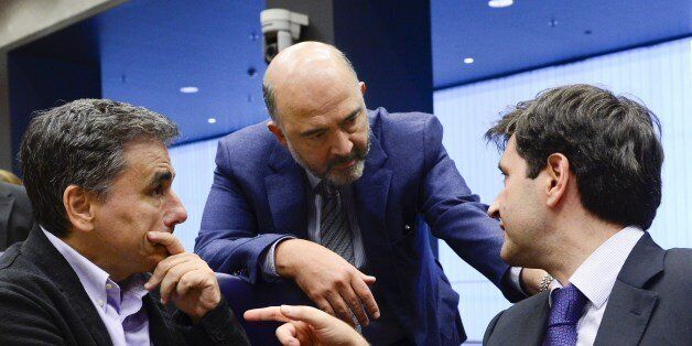 Greek Finance Minister Euclid Tsakalotos (L) talks with EU Commissioner of Economic and Financial Affairs, Taxation and Customs Pierre Moscovici (C) and Greece's deputy finance minister George Chouliarakis (R) during an Eurogroup meeting on October 05, 2015 in Luxembourg. AFP PHOTO / JOHN THYS (Photo credit should read JOHN THYS/AFP/Getty Images)