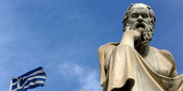 A Greek flag flutters by a statue of ancient Greek philosopher Socrates in central Athens March 18, 2015. Greek Prime Minister Alexis Tsipras on Wednesday hit back at reported criticism from European partners on a bill legislating food stamps and free electricity to the poor, saying his government will not be scared into complying with lenders.REUTERS/Yannis Behrakis (GREECE - Tags: POLITICS BUSINESS)