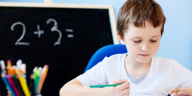 Seven years old boy, child doing his homework. Back to school