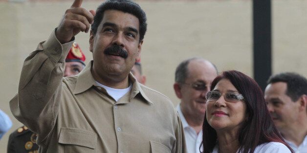 Venezuela's President Nicolas Maduro, left, speaks with his wife, first Lady Cilia Flores as they wait for Colombia's President Juan Manuel Santos prior a meeting in Puerto Ordaz, Venezuela, Thursday, Aug. 11, 2016. The two South American leaders met Thursday to assess the situation on the Venezuelan-Colombian border, and to discuss the possibility of reopening of border crossings closed now for almost a year. (AP Photo/Fernando Llano)