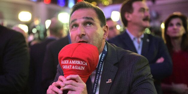 A Republican presidential nominee Donald Trump's supporter watches result unfold on a screen during election night at the New York Hilton Midtown in New York on November 8, 2016. / AFP / Mandel NGAN (Photo credit should read MANDEL NGAN/AFP/Getty Images)
