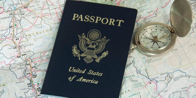 A United States passport resting on a map with a compass.