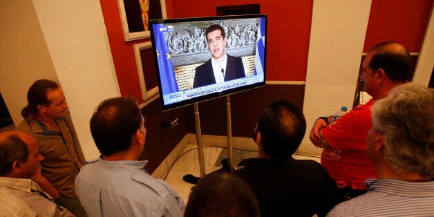 'No' supporters watch Greek Prime Minister Alexis Tsipras speaking on TV at Zappeion conference centre in Athens, Greece July 5, 2015. Greeks voted overwhelmingly