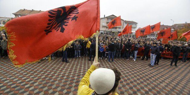 PRESEVO, SERBIA - NOVEMBER 11: A boy waves Albanian flag during Albanian Prime Minister Edi Rama's visit in Presevo, a Serbian town highly populated by Albanians, Serbia, on November 11, 2014. This is the first visit to Serbia by an Albanian premier in almost seven decades. (Photo by Samir Yordamovic/Anadolu Agency/Getty Images)