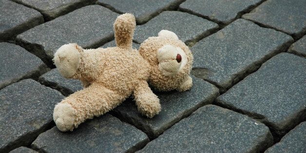 Little teddy-bear laying on the pavement