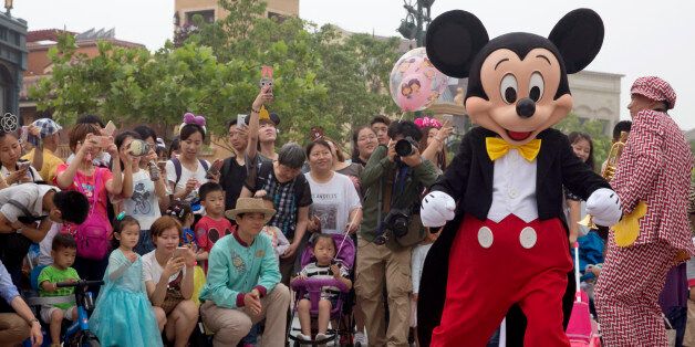 Mickey Mouse entertains visitors on the opening day of the Disney Resort in Shanghai, China, Thursday, June 16, 2016. Walt Disney Co. opened its first theme park in mainland China on Thursday at a ceremony that mixed speeches by Communist Party officials, a Chinese children's choir and actors dressed as Sleeping Beauty and other Disney characters. (AP Photo/Ng Han Guan)