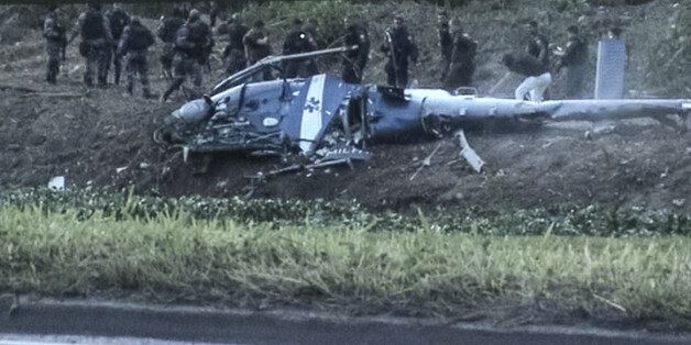 A screen shot taken from a video shows police officers investigating the crashed police helicopter that killed four officers during their operation against drug dealers at Cidade de Deus favela (community) in Rio de Janeiro on November 19, 2016. / AFP / STR (Photo credit should read STR/AFP/Getty Images)