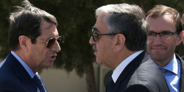 FILE- In this Wednesday, Sept. 14, 2016 file photo, Cypriot President Nicos Anastasiades, left, and breakaway Turkish Cypriot leader Mustafa Akinci, right, talks as the UN Special Advisor of the Secretary-General Espen Barth Eide, right, looks on as they leave their talks aimed at reunifying the ethnically divided island, at the disused Nicosia airport inside a United Nations controlled buffer zone. Cyprusâ president said Friday, Sept. 30, 2016, an insistence by breakaway Turkish Cypriots to cede Turkey the right to militarily intervene under a hoped-for deal reunifying the divided Mediterranean island nation is âexcessive and unjustified.â (AP Photo/Petros Karadjias, File)