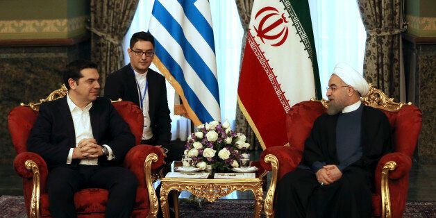 Iranian President Hassan Rouhani, right, meets with Greek Prime Minister Alexis Tsipras in Tehran, Iran, Monday, Feb. 8, 2016. An unidentified interpreter sits at background. (AP Photo/Vahid Salemi)