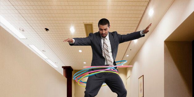 Mixed race businessman on conference table spinning plastic hoops