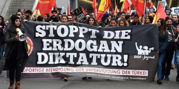 People attend a pro-Kurdish demonstration with a banner reading 'Stop Erdogan's dictatorship' in Cologne, western Germany, on November 5, 2016 as part of an international day in support to Kurds.Germany on Friday summoned Turkey's envoy after Ankara detained almost a dozen lawmakers from the main pro-Kurdish party, warning that a crackdown against terror should not be used as an excuse to silence the opposition. / AFP / PATRIK STOLLARZ (Photo credit should read PATRIK STOLLARZ/AFP/Getty Images)