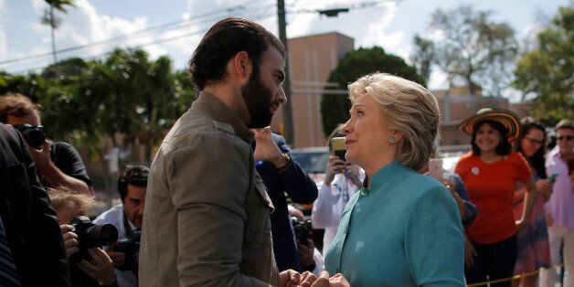 U.S. Democratic presidential nominee Hillary Clinton talks to actor and singer Jencarlos Canela while visitiing an early voting site in West Miami, Florida, U.S. November 5, 2016. REUTERS/Brian Snyder