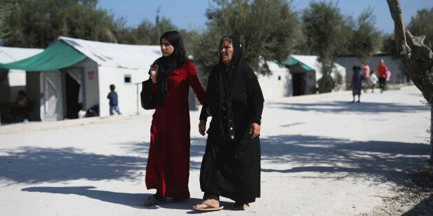 Two Syrian women walk at the Kara Tepe camp for refugees and other migrants on Lesbos island, Greece, on Thursday, Oct. 6, 2016. More than a million migrants and refugees crossed through Greece and on to other EU countries since the start of 2016, while over 60,000 have been stranded in the country since the EU-Turkey deal took effect and the Balkan transit route north was closed. (AP Photo/Petros Giannakouris)