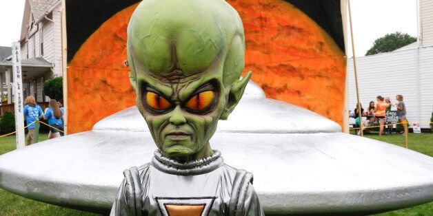 A figure representing a green alien is positioned in front of the permanent flying saucer replica in Mars, Pa. on Friday, June 19, 2015. The small western Pennsylvania town has NASA joining in with a weekend celebration of the Northern Hemisphere Spring Equinox on the planet Mars, marking the start of a new year on the red planet which lasts about 687 Earth days. NASA provided exhibits, booths and outreach activities for the three-day celebration. (AP Photo/Keith Srakocic)