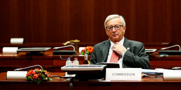 European Commission President Jean-Claude Juncker adjusts his tie as he sits in his seat prior to the start of a round table session during the EU Summit in Brussels, Friday, Oct. 21, 2016. (AP Photo/Alastair Grant)