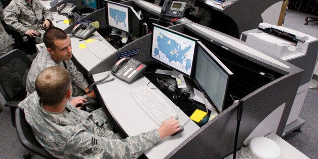 Personnel work at the Air Force Space Command Network Operations & Security Center at Peterson Air Force Base in Colorado Springs, Colorado July 20, 2010. U.S. national security planners are proposing that the 21st century's critical infrastructure -- power grids, communications, water utilities, financial networks -- be similarly shielded from cyber marauders and other foes. The ramparts would be virtual, their perimeters policed by the Pentagon and backed by digital weapons capable of circling the globe in milliseconds to knock out targets. To match Special Report USA-CYBERWAR/ REUTERS/Rick Wilking (UNITED STATES - Tags: MILITARY SCI TECH POLITICS)