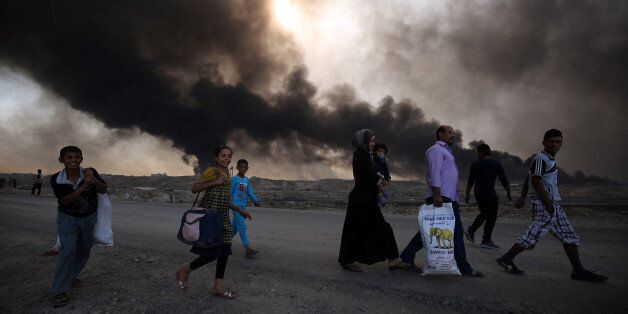 TOPSHOT - Displaced Iraqi families arrive near a checkpoint east of Mosul as they flea areas of unrest, on October 22, 2016, during an operation by the Iraqi army to retake the main hub city from the Islamic State (IS) group jihadists.Mosul is the most populous city in the 'caliphate' Baghdadi declared in June 2014, and the operation to recapture it is Iraq's largest in years. / AFP / AHMAD AL-RUBAYE (Photo credit should read AHMAD AL-RUBAYE/AFP/Getty Images)