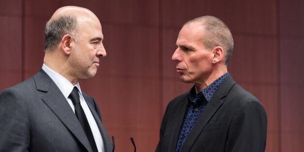 European Commissioner for Economic and Financial Affairs Pierre Moscovici, left, talks with Greek Finance Minister Yanis Varoufakis during a meeting of eurogroup finance ministers at the European Council building in Brussels, Monday March 9, 2015. (AP Photo/Geert Vanden Wijngaert)