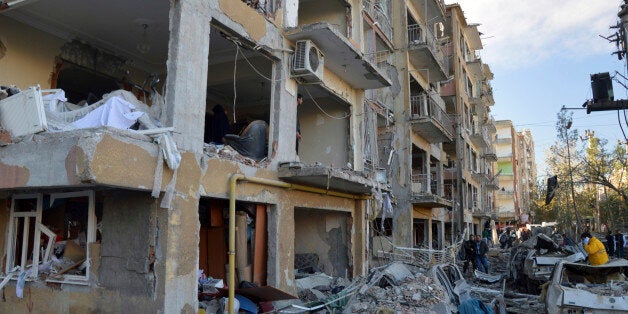 People view the damage after an explosion in the southeastern Turkish city of Diyarbakir, early Friday, Nov. 4, 2016. A large explosion hit Diyarbakir, the largest city in Turkey's mainly Kurdish southeast region on Friday, wounding several people the state-run Anadolu Agency reported. The cause of the explosion was not immediately known but Hurriyet newspaper said it may have been caused by a car bomb. (IHA via AP)