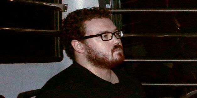 FILE PHOTO - Rurik George Caton Jutting, a British banker charged with two counts of murder after police found the bodies of two women in his apartment, sitting in the back row of a prison bus as he arrives at the Eastern Law Courts in Hong Kong November 24, 2014. REUTERS/Bobby Yip/File Photo TPX IMAGES OF THE DAY