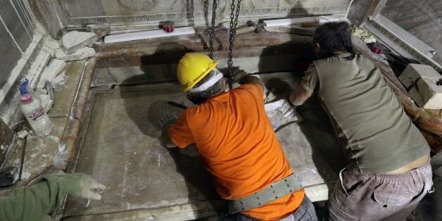 Greek preservation experts place back the marble slab stone that covered the Tomb of Jesus, where his body is believed to have been laid, after it was removed for 3 days to allow the team to do restoration works and study as part of conservation work done by the Greek team in Jerusalem on late on October 28, 2016.The experts from the National Technical University of Athens for cultural heritage preservation removed the marble slab stone that covered the original tomb since the last restoration of the edicule on 1810 by Greek architect Nikolaos Komnenos. The Church of the Holy Sepulchre in Jerusalems Old City is traditionally believed to be the site of Jesuss burial and attracts every year millions of pilgrims from all over the world. / AFP / GALI TIBBON (Photo credit should read GALI TIBBON/AFP/Getty Images)