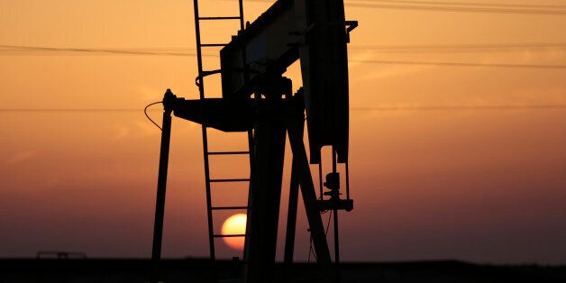 FILE -- In this April 16, 2016 file photo, an oil pump works at sunset in the desert oil fields of Sakhir, Bahrain. The head of the International Monetary Fund in the Mideast, Dr. Masood Ahmed told The Associated Press, Tuesday, Oct. 18, 2016, that oil-producing Mideast countries âstill have some way to goâ in reforming the government sector and cutting spending. He said that nations are making efforts to cope with low oil prices, though more needs to be done. (AP Photo/Hasan Jamali, File)