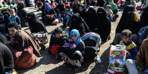 Iraqi families, who fled the violence due to the ongoing operation by Iraqi forces against jihadists of the Islamic State group to retake the city of Mosul, wait to board a truck before heading to camps housing displaced people on November 3, 2016 near Gogjali, which lies on the eastern edge of Mosul.Some civilians were leaving Gogjali and others the eastern Mosul neighbourhood of Samah, in what may be a rare breach for civilians trapped inside the city. More than 21,000 people have fled to gove