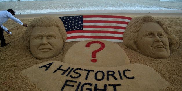 Visitors look near to the sand sculpture creating by sand artist Sudarsan Pattnaik of USA presidential candidate Hillary Clinton and Donald Trump with message "A Historic Fight" at the Bay of Bengal Seas eastern coast beach at Puri, 65 km away from the eastern Indian city Bhubaneswar, Wednesday, 02 November 2016. (Photo by STR/NurPhoto via Getty Images)